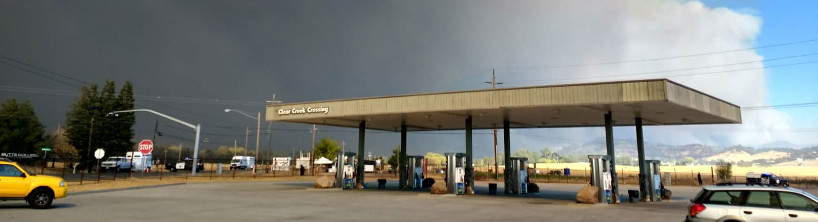 gas station with smoke from a fire in the background